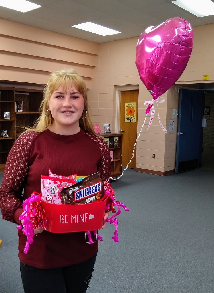 Annelise holds a basket with Valentines treats and a balloon